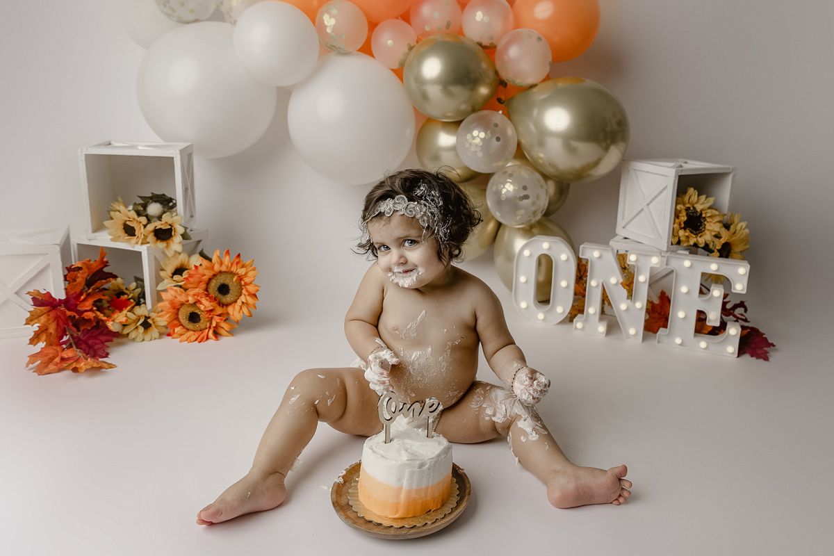 Cake Smash photo shoot with one year old girl orange and gold
