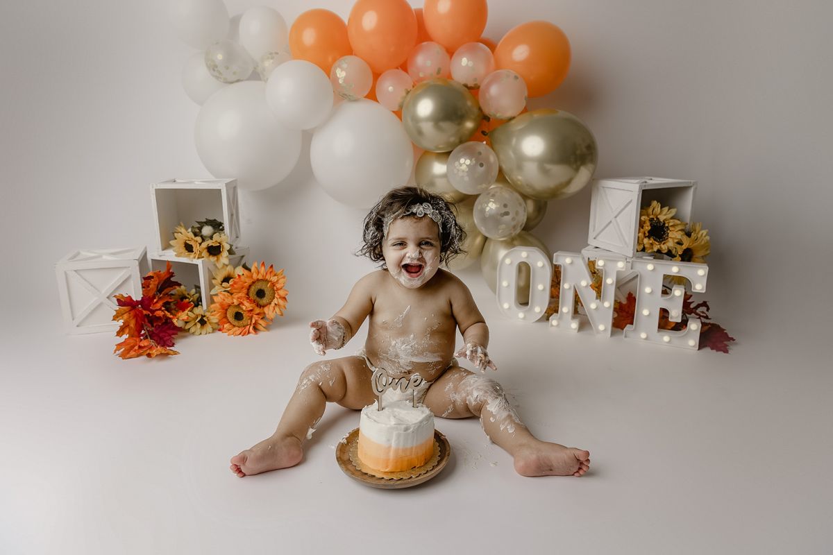 Happy baby girl at her cake smash photo shoot