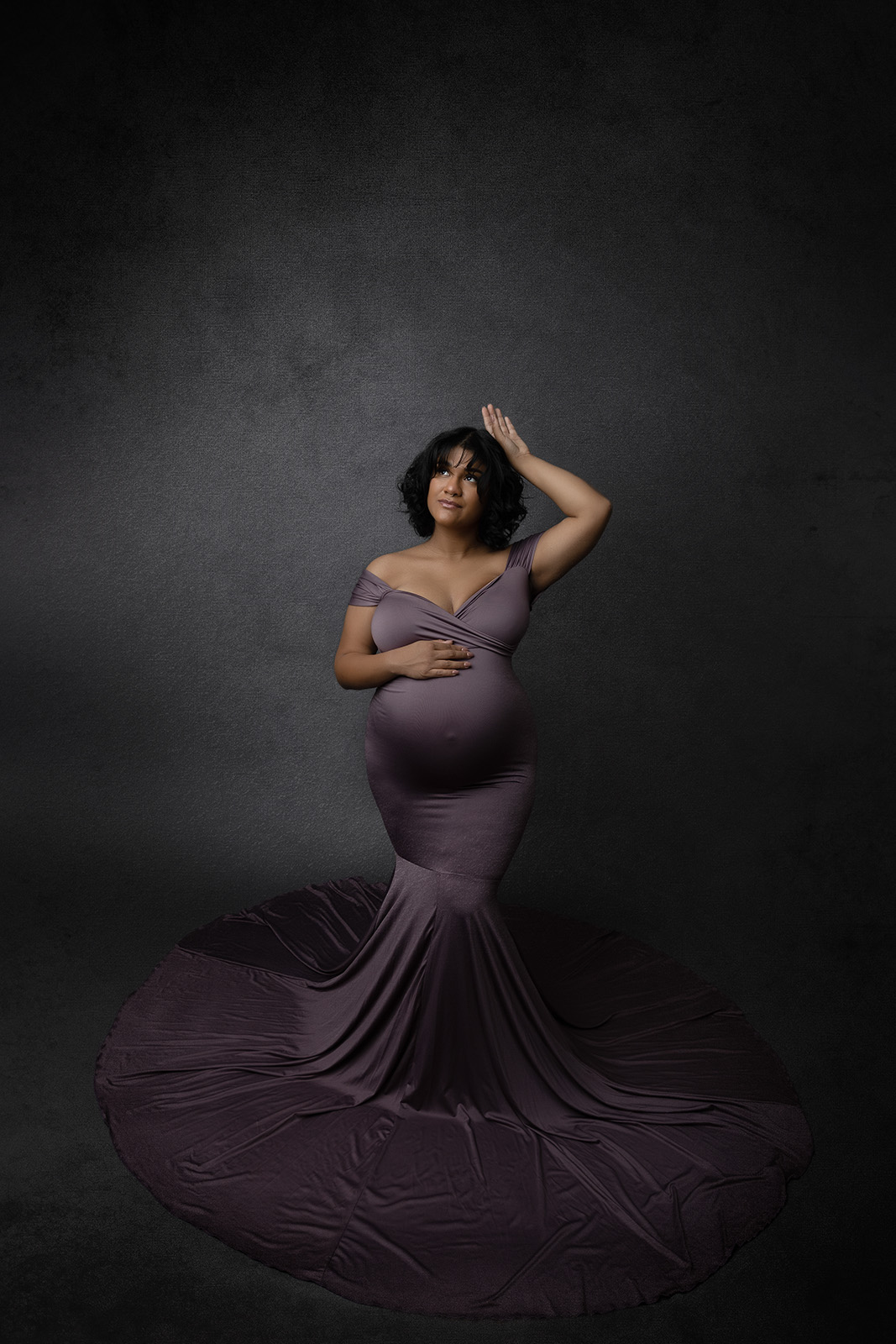 Mom to be is wearing an elegant purple dress from Chicaboo