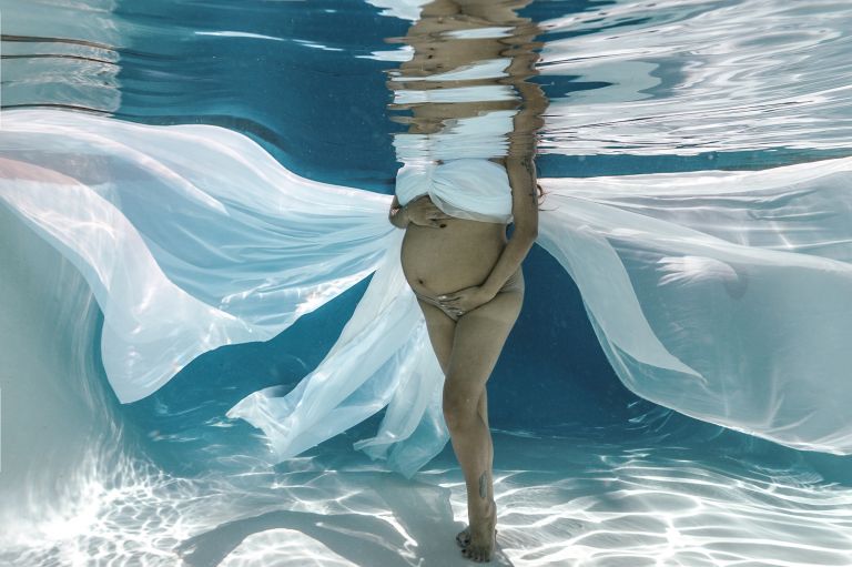 Luxury underwater maternity photography Dallas in a heated pool