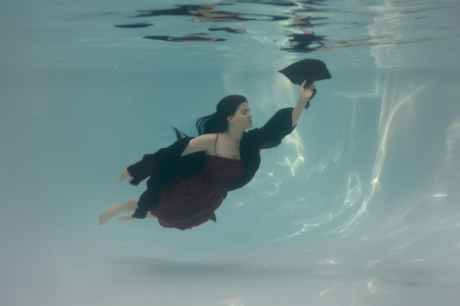 Dallas senior underwater graduation portrait, high school student in cap and gown floating underwater, fine art senior photography by White Lavender Photography