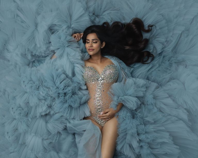 Top maternity poses in Dallas featuring signature laying-down pose with flowing fabric, luxury maternity photography by White Lavender Photography